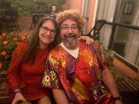 A couple seated outdoors at the auction, smiling.