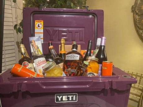 A cooler packed with bottles and snacks as a lot.