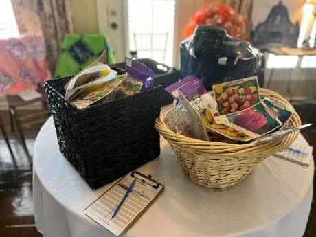 Baskets on a dressed round table with bid sheets.